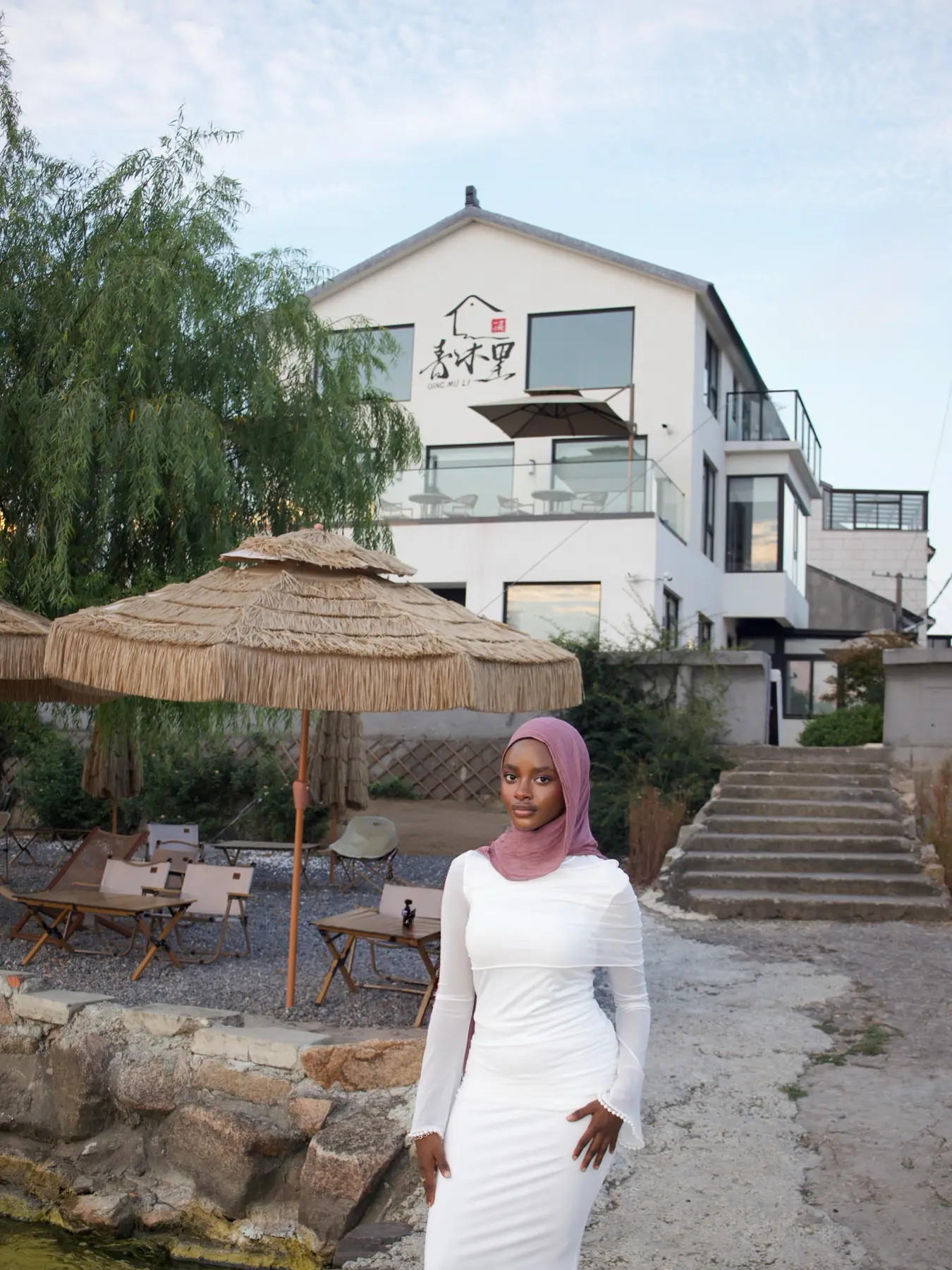 Amina in a white dress beside the water